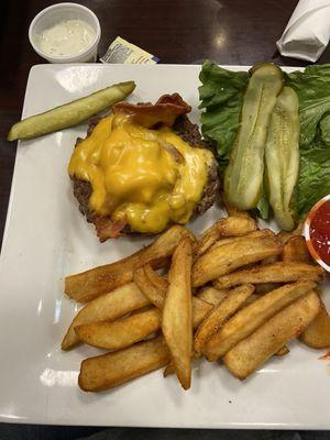 Bacon cheese burger with shriveled pickles and a side pickle that looks like a kid chewed on it.