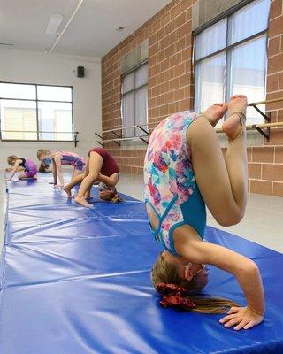 Working on headstands in a tumbling class