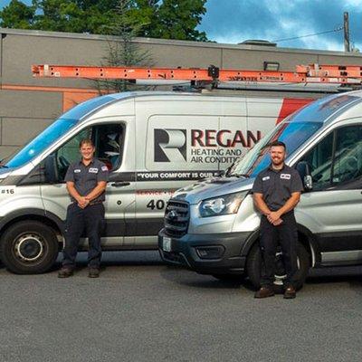 Regan Heating & Air Conditioning technicians with their vehicles.