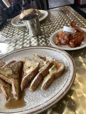 French toast, powdered sugar, butter, cinnamon, roll, bacon, apple juice, and sprite the table hologram