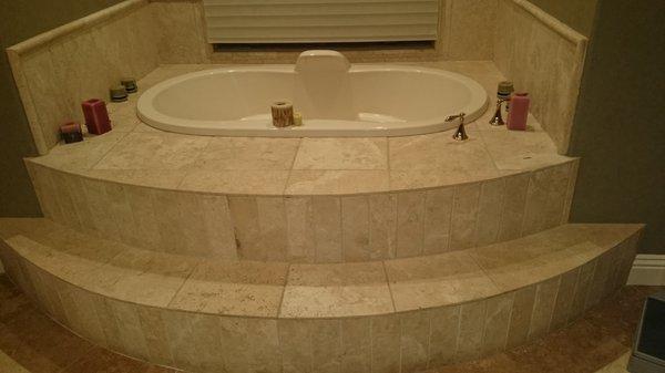 Jacuzzi tub with travertine stone installed with travertine border flooring and surround.