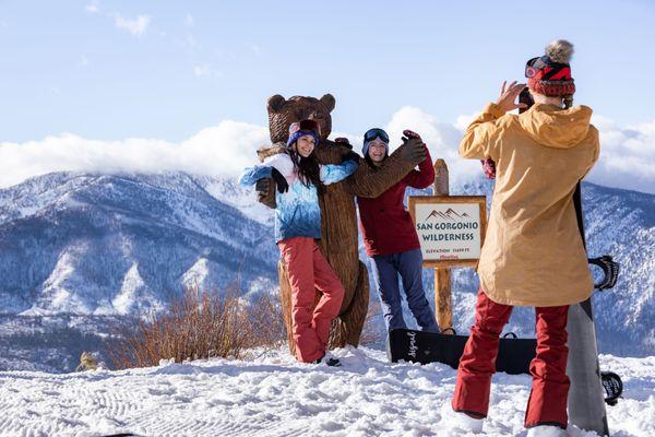 Adults posing at the top of Bear Mountain.