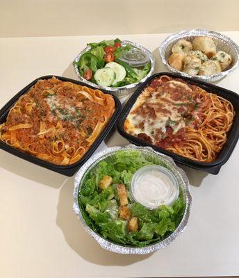 Fettuccine Bolognese $16 (left) and Chicken Parmesan $20 (right) served with salads and garlic rolls