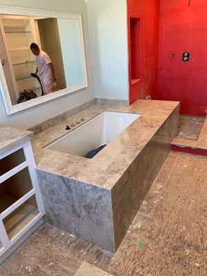 under mount tub with stone surface installed with waterfall design