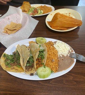 Barbacoa, cheek, and Al pastor tacos, a beef chimichanga, tamale