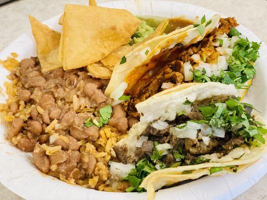 El pastor and carne asada tacos, rice and beans and chips and guac