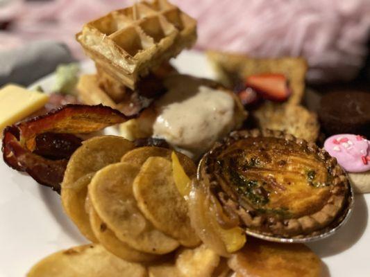 part of the offerings of Galentine's day brunch 2024 chicken & waffle sandwich, , biscuit and gravy , quiche,, bacon & sausage and potatoes