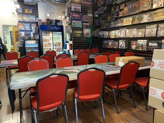 Table and chairs for tabletop gaming within store, plus bathroom in back.