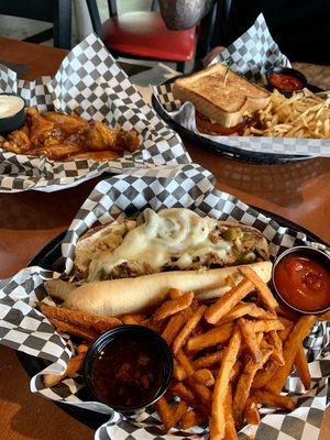 Chicken cheesesteak w/ sweet potato fries, cheeseburger on Texas toast w/ fries, and mango habanero wings with house made blue cheese