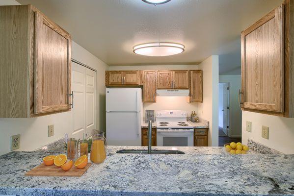 Kitchen with granite countertops, soft-close cabinetry and pass-through dining nook.