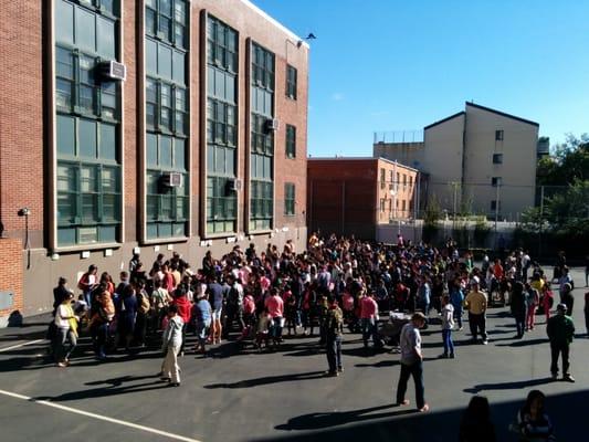 morning lineup on two sides of the school yard, kids waiting to enter class