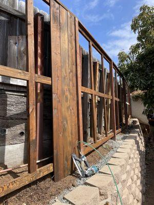 section of pre stained wood fence backing up to pool.