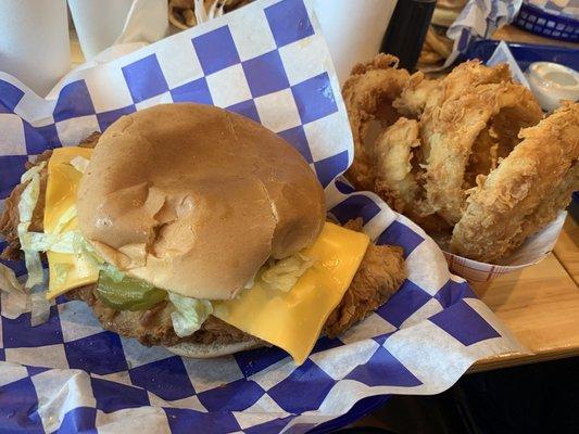 Chicken fried sandwich with cheese added and onion rings