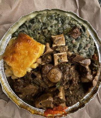 Oxtails with macaroni, rice and peas and callaloo