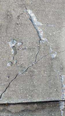 Gouges and new cracks on my driveway, caused by the placement of Sheegog's waste dumpster.