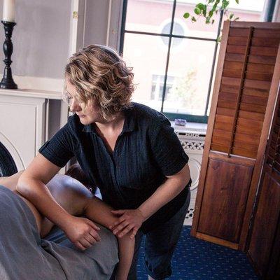 The business owner working with a client during a therapeutic session.