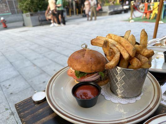 Burger with a veggie patty and fries, while seated outdoors