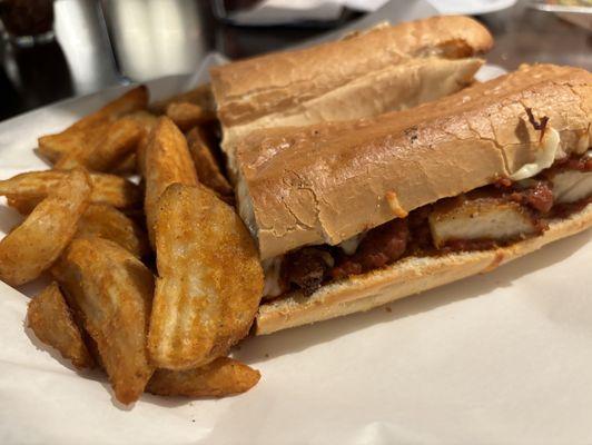 Chicken parm sandwich with potato wedges.