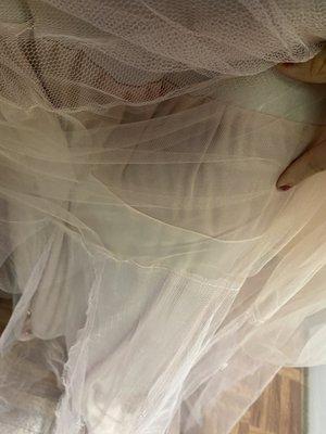 Close up of them cutting the lining of the dress and tulle as well