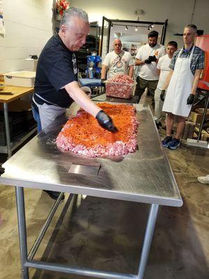 Oven room, adding spices to ground meat.