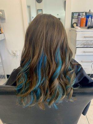 Mermaid blue peekaboo highlights added to natural brown hair