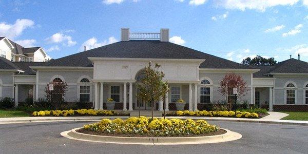 a large white house with yellow flowers in front of it