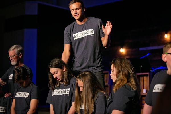 Pastor Seth Lochmueller praying over youth.