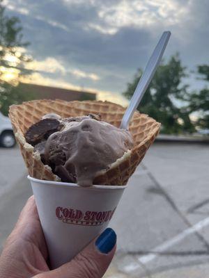 Chocolate ice cream with peanut butter cup in a waffle cone