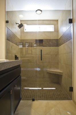 Tile installation San Diego, CA. Deco stripe, recessed shampoo shelf, window wrap, corner seat, frameless glass enclosure