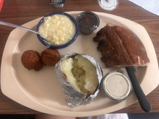 Baby Back Ribs with baked potato, creamed corn and hush puppies.