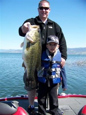 Dad shows off a fish almost as big as his son