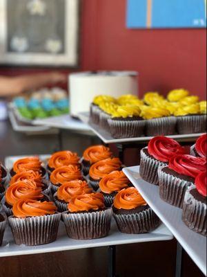 Cupcakes, rainbow colored and chocolate with a raspberry filling.