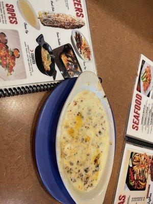 Watery cheese dip that's supposed to be queso fundido next to a menu photo falsely advertising proper queso fundido