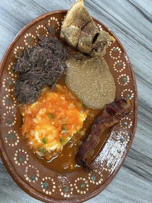 Huevos rancheros , barbacoa , beans , bacon, and Chicharron