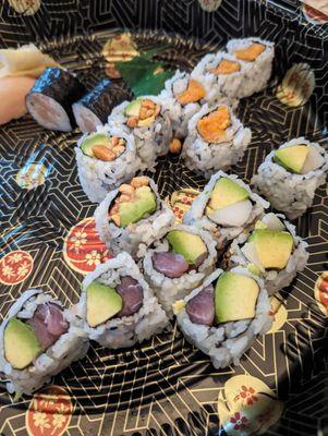 Clockwise from top right: An assortment of spicy yellowtail, white tuna/ avocado, tuna/ avocado, peanut avocado, and hamachi roll.