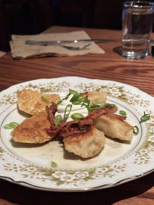 Loaded pierogis with bacon, green onions, and sour cream.