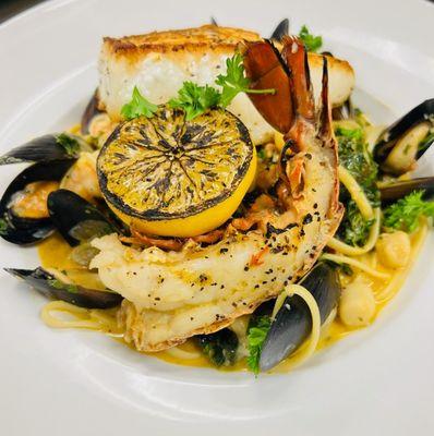 Seafood Pasta: Mussels, Bay Scallops, Shrimp, Kale, & Linguine tossed in a Creamy Seafood Tomato Broth t/w Seared Seabass & Lobster Tail