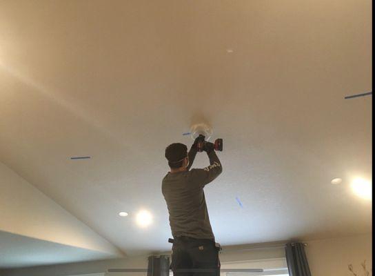 Dave adding additional can lights in our living room.