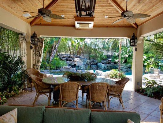 Outdoor seating area with a view of pool & spa. Patio Cover, Tiles & Rock Formations for pool built by DC Landscapes.