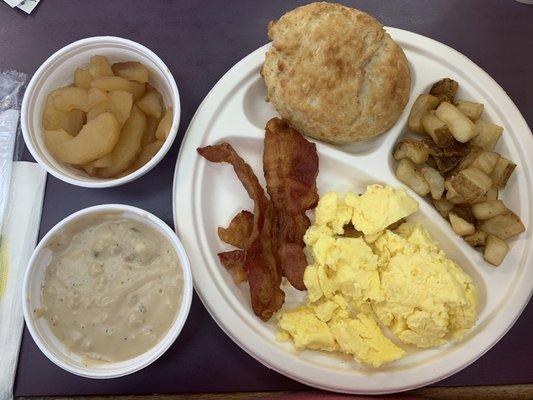 Fried apples, gravy, bacon, scrambled, fried potatoes and a biscuit