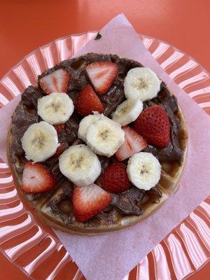 Freshly made waffle with Nutella berries and banana