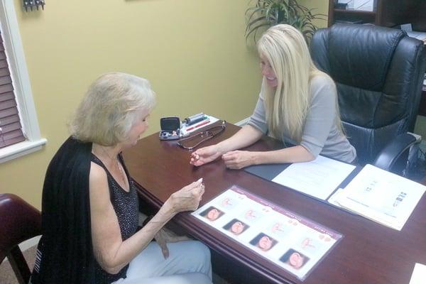 Lori helping a new client select the best hearing aid for her.