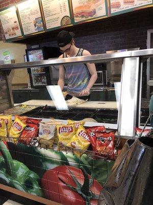 An employee making a sandwich in a tank top!   Gross!!