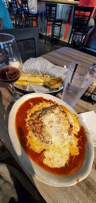 Lasagna with lots of garlic bread $12.99, glass of house Cabernet