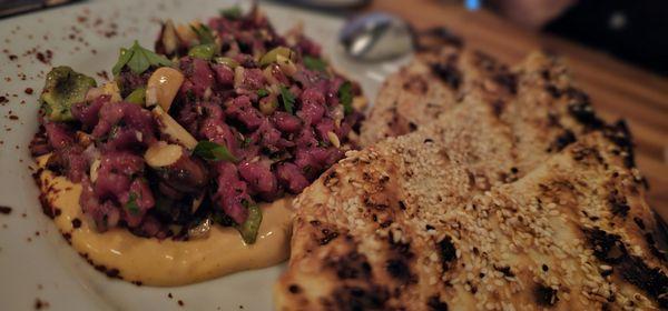 Lamb tartare with green olives, almonds, and sesame seed crusted flat bread. DELICIOUS