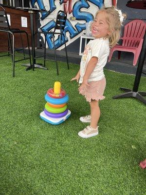 A very happy girl enjoying the lawn / board games available within patio waiting area