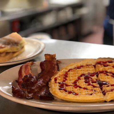 Apple stuffed pancake, waffle with raspberry drizzle and bacon