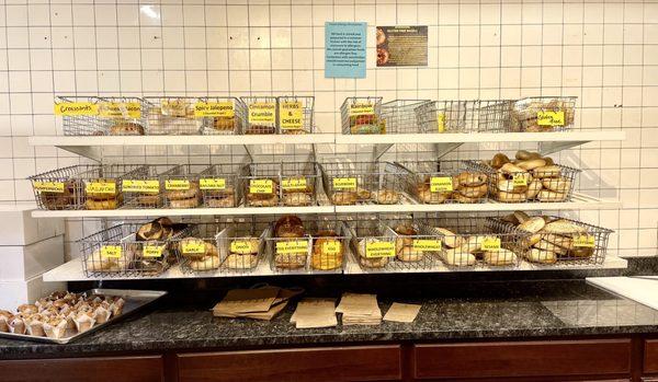 Display of housemade bagels behind the counter - zoom in to see flavors