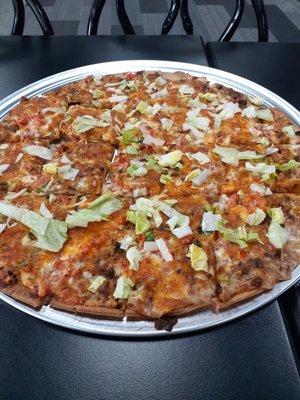 Taco pizza with light lettuce.