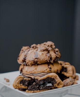 The Reverse Cookie! Peanut Butter Cookie Stuffed with a Chocolate Cookie, Stuffed with a Fudge Center. Topped with Reese's PB cups.